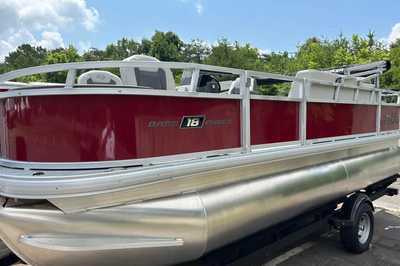 Slide: The Image of 2026 Sun Tracker Bass Buggy 18 DLX pontoon boat with red exterior on a trailer. - 1