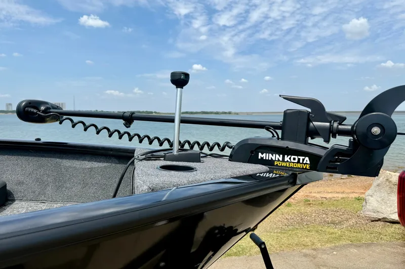 Slide: The Image of 2026 Tracker Pro Guide V-175 Combo boat with Minn Kota PowerDrive motor by a lake. - 3