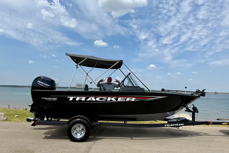 The Image of 2026 Tracker Pro Guide V-175 Combo boat by the water under a cloudy sky. - 0