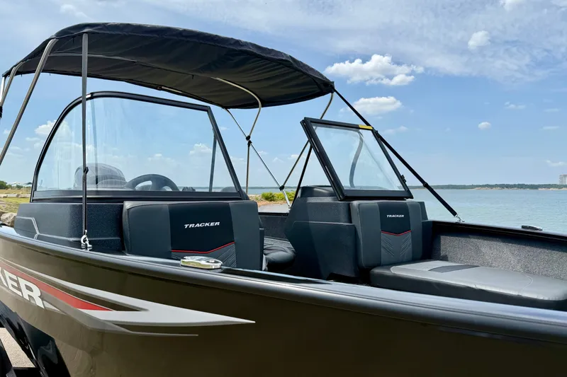 Slide: The Image of 2026 Tracker Pro Guide V-175 Combo boat with canopy, near a serene lake. - 5