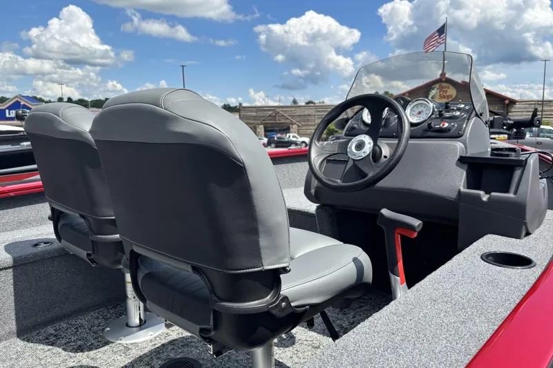 Slide: The Image of 2026 Tracker Super Guide V-16 SC boat interior with steering wheel and seats under a blue sky. - 4