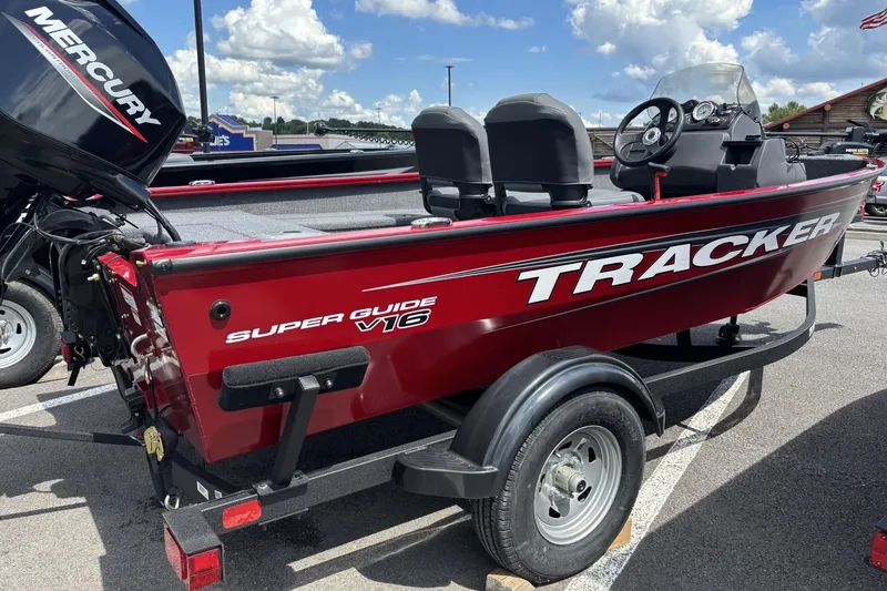 The Image of 2026 Tracker Super Guide V-16 SC boat on trailer, red exterior, parked outdoors. - 0