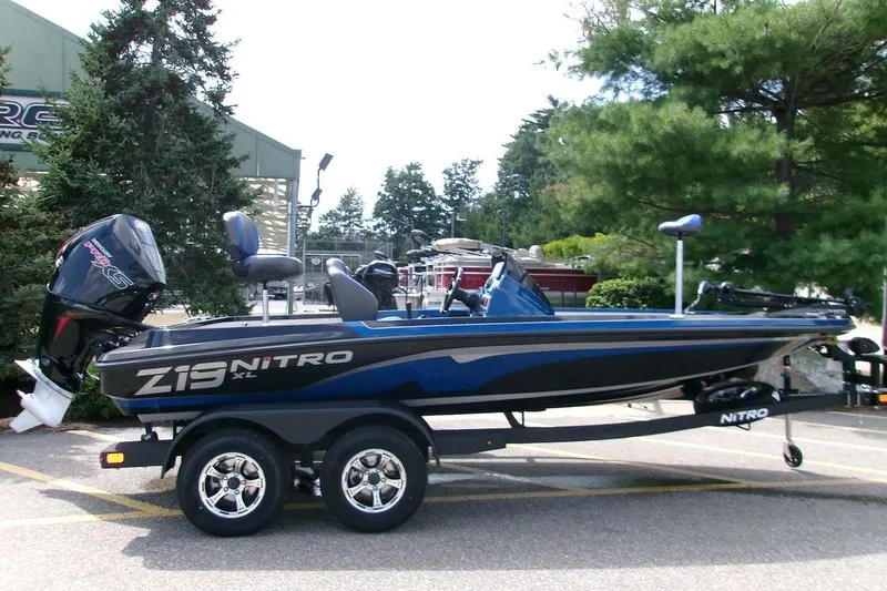 The Image of 2026 Nitro Z19 XL boat on trailer, parked outdoors near trees. - 0
