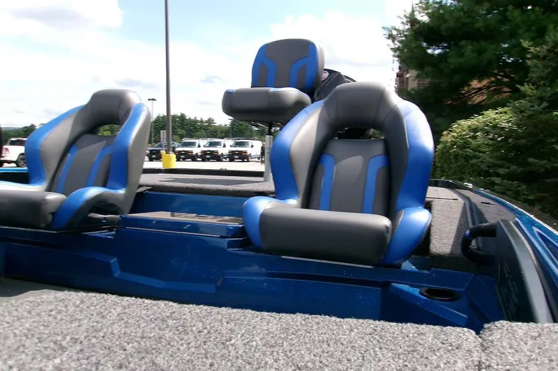 Slide: The Image of 2026 Nitro Z19 XL boat interior with blue and gray seats, parked outdoors. - 9