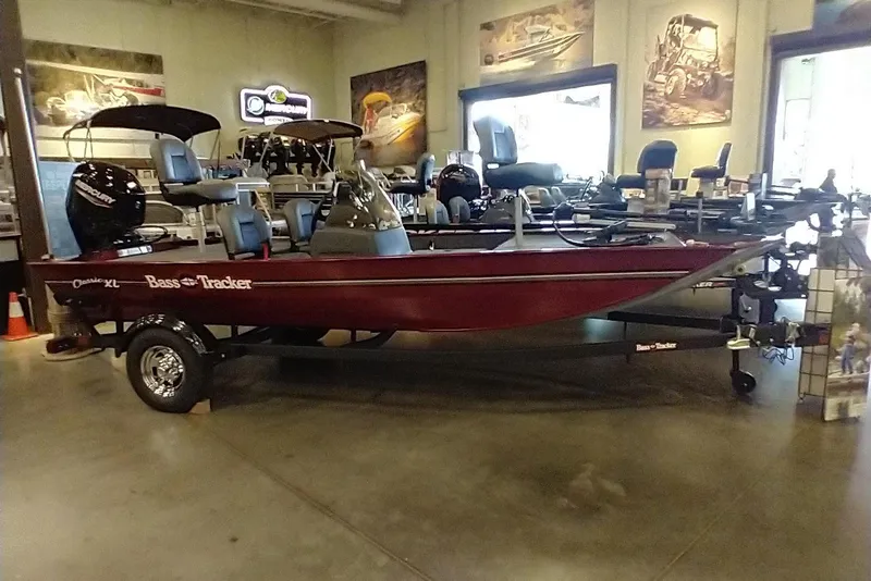 The Image of 2026 Tracker Bass Tracker Classic XL boat displayed in showroom with fishing seats and motor. - 0