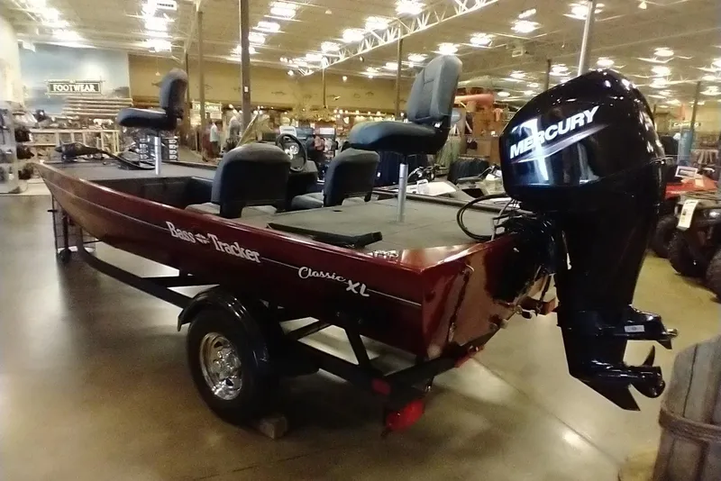 Slide: The Image of 2026 Tracker Bass Tracker Classic XL boat with Mercury engine displayed indoors. - 3