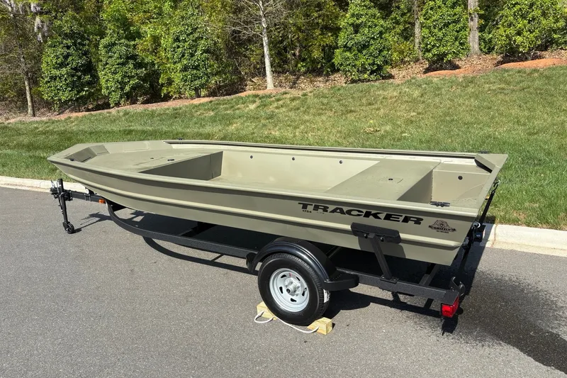 Slide: The Image of 2026 Tracker Grizzly 1754 Utility boat on trailer, parked on a sunny road. - 4