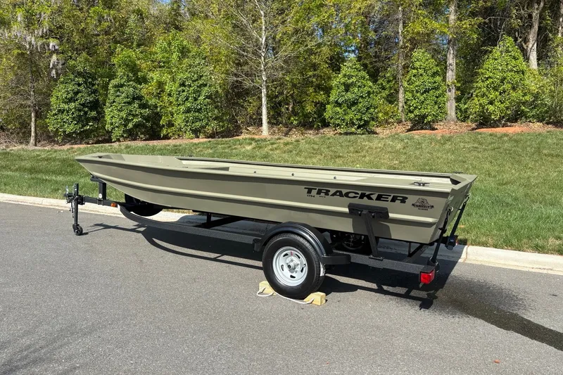 Slide: The Image of 2026 Tracker Grizzly 1754 Utility boat on trailer, parked on a sunny road. - 3