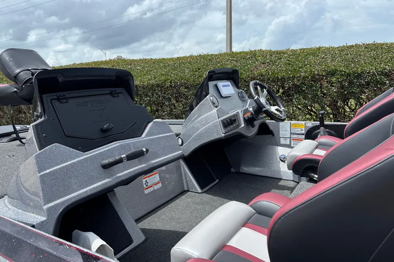 Slide: The Image of 2026 Nitro Z18 boat interior with steering wheel and seating, under a cloudy sky. - 16