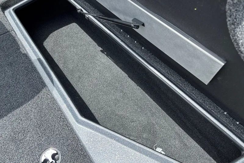 Slide: The Image of Open storage compartment in 2026 Nitro Z18 boat, featuring carpeted interior and hydraulic lift support. - 23