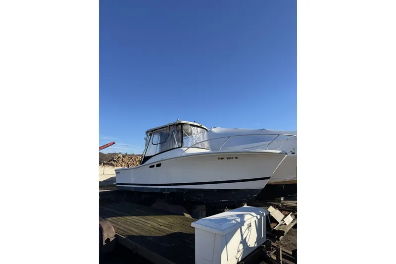 The Image of 1993 Luhr's Tournament boat on dry dock under clear blue sky. - 1