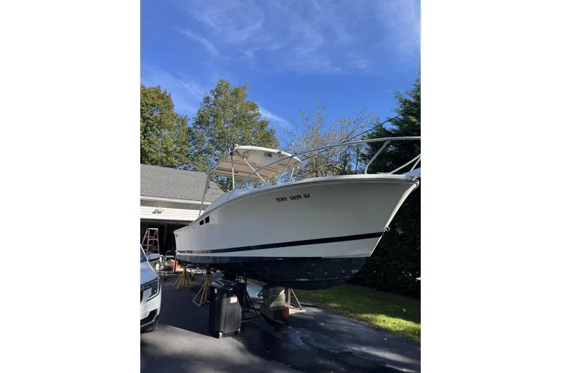 Slide: The Image of 1993 Luhr's Tournament boat on trailer, parked in driveway under clear blue sky. - 3