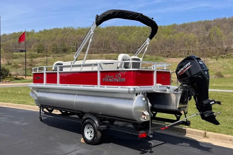 Slide: The Image of 2026 Sun Tracker Bass Buggy 18 DLX pontoon boat with Mercury engine on trailer. - 2