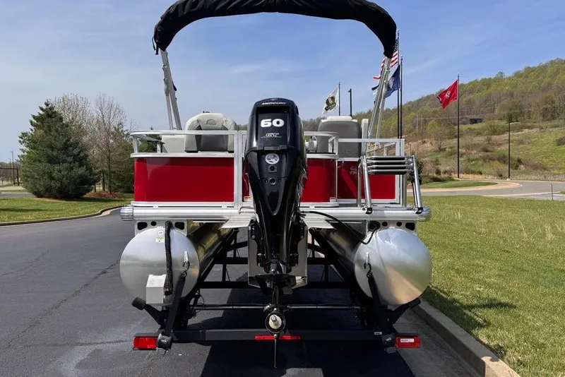 Slide: The Image of 2026 Sun Tracker Bass Buggy 18 DLX pontoon boat with 60 HP engine, parked outdoors. - 6