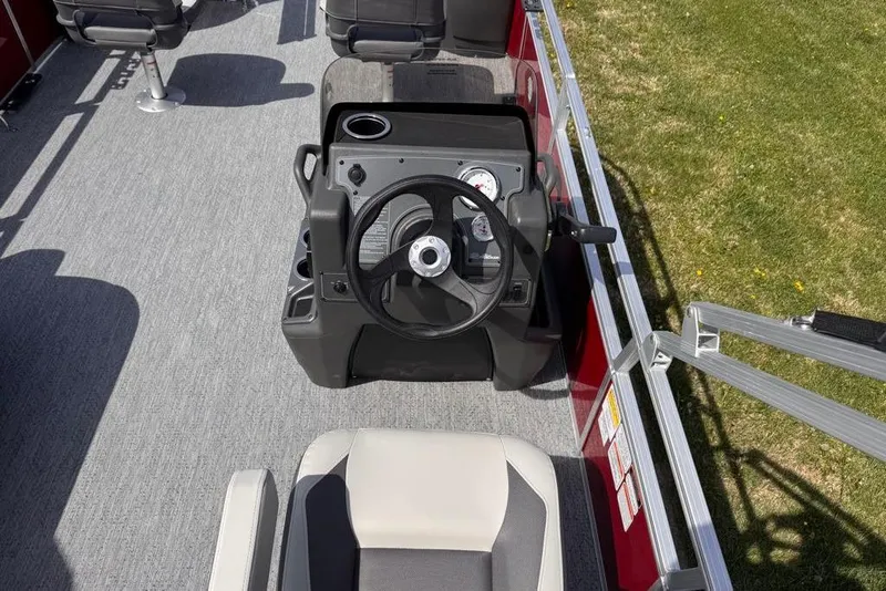 Slide: The Image of 2026 Sun Tracker Bass Buggy 18 DLX pontoon boat helm with steering wheel and seating. - 76