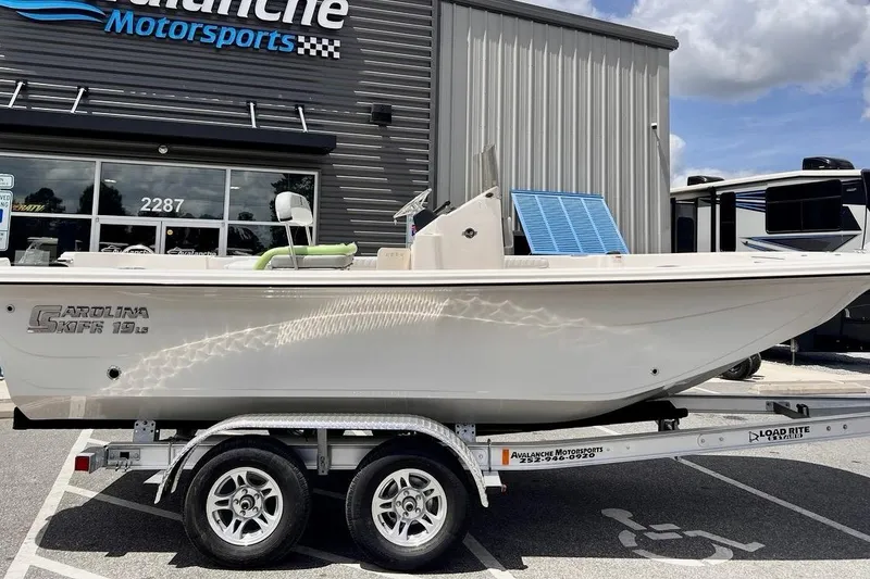 Slide: The Image of 2026 Carolina Skiff 19 LS boat on trailer at dealership, sunny day. - 8
