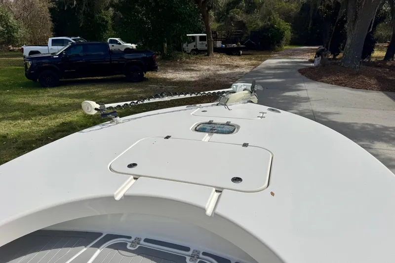 Slide: The Image of Bow of 2021 ZCB 26 Freemason boat with trolling motor, parked near trucks. - 12