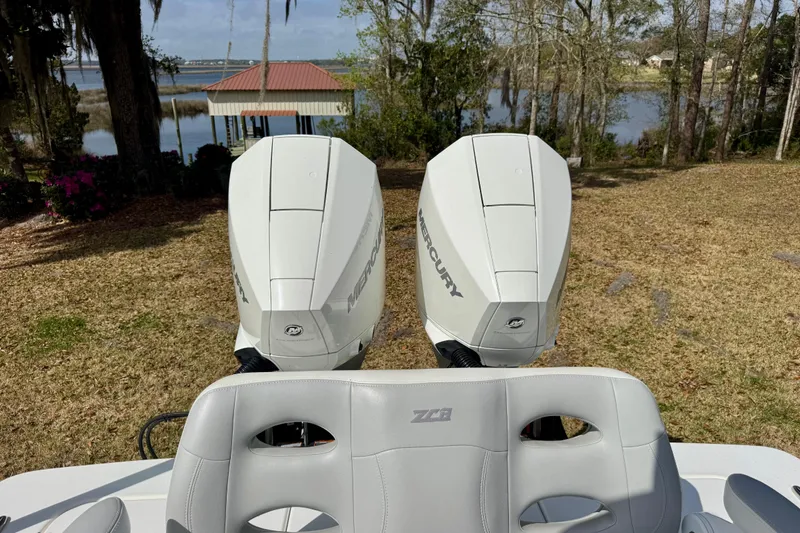 Slide: The Image of 2021 ZCB 26 Freemason boat with dual Mercury outboard engines, scenic lakeside view. - 21
