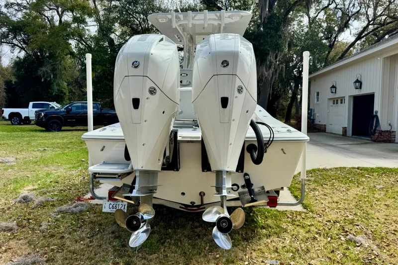 Slide: The Image of 2021 ZCB 26 Freemason boat with dual outboard motors in a yard setting. - 4
