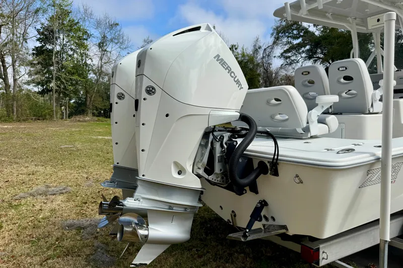 Slide: The Image of 2021 ZCB 26 Freemason boat with dual Mercury outboard engines on grassy area. - 5