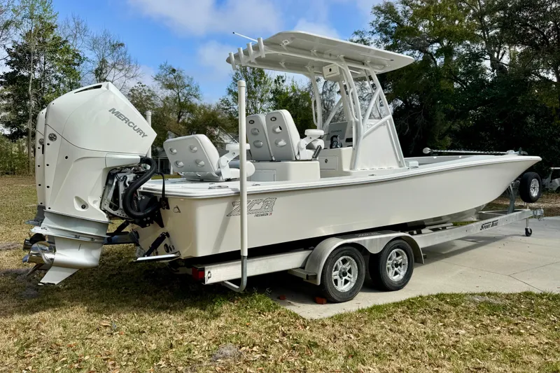Slide: The Image of 2021 ZCB 26 Freemason boat on trailer with Mercury engine, parked outdoors. - 3