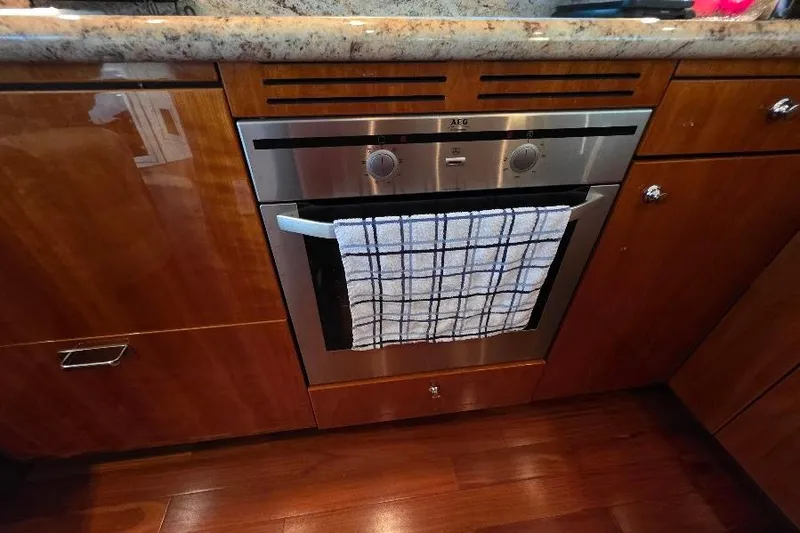 Slide: The Image of Luxury yacht kitchen with AEG oven, wooden cabinetry, and granite countertop on 2008 Neptunus Flybridge MY. - 60
