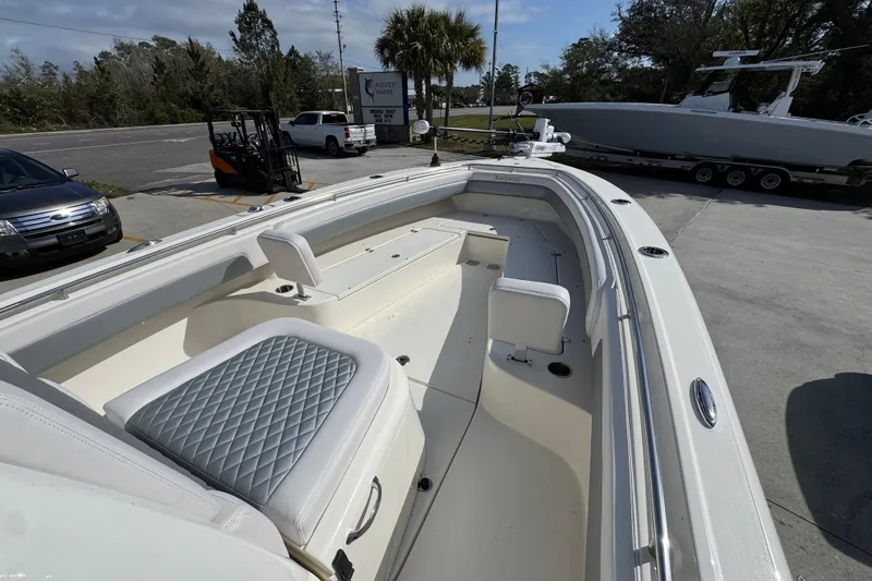 Slide: The Image of 2026 Blackwood 270 LXF boat with spacious seating and sleek design in a parking area. - 16