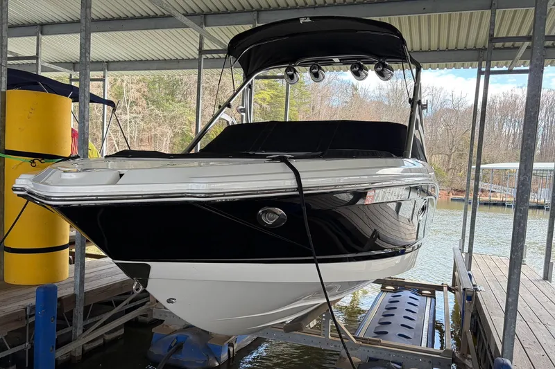 Slide: The Image of 2012 Chaparral 246 SSi boat docked under a covered marina, side view. - 3