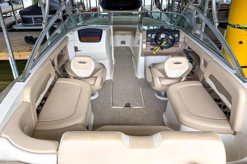 Slide: The Image of 2012 Chaparral 246 SSi boat interior with beige seating and modern dashboard. - 6