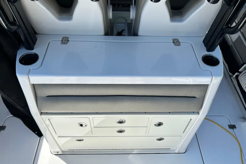 Slide: The Image of 2021 Sportsman Open 302 Center Console boat interior with storage drawers and cup holders. - 16