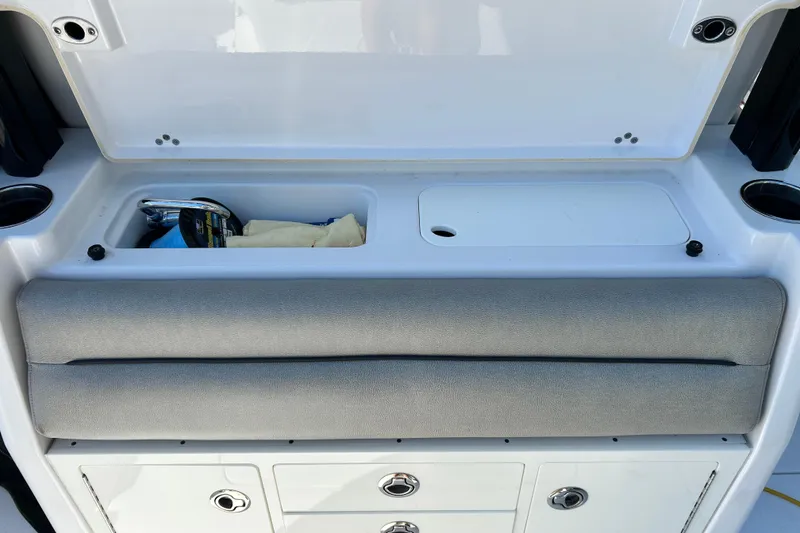 Slide: The Image of 2021 Sportsman Open 302 Center Console storage area with cushioned seating and compartments. - 17