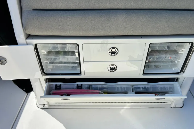Slide: The Image of 2021 Sportsman Open 302 Center Console storage compartments with organized fishing gear. - 18