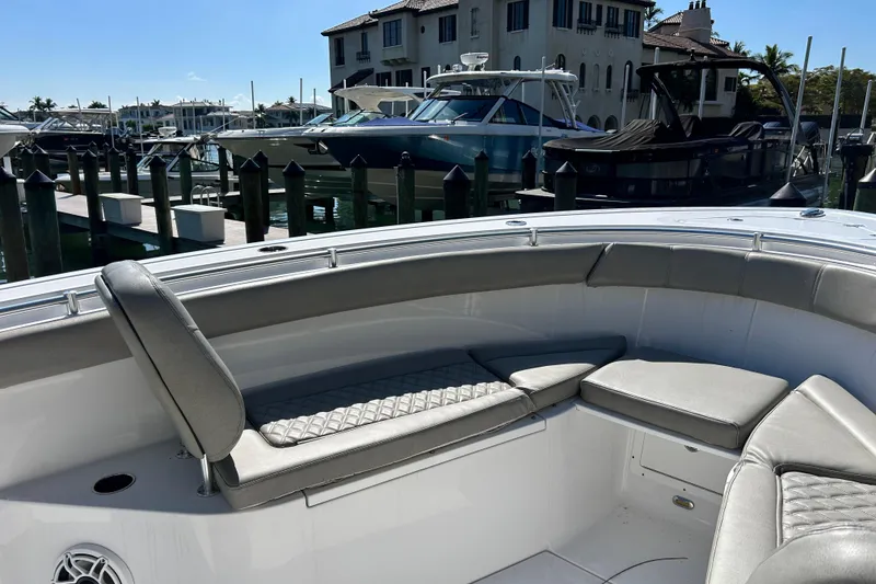 Slide: The Image of 2021 Sportsman Open 302 Center Console boat docked in a marina with luxurious seating. - 8