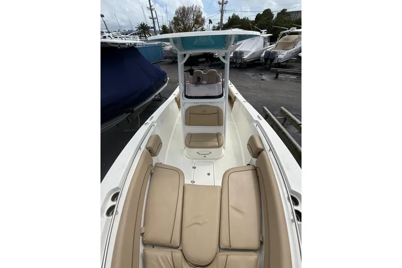 Slide: The Image of 2019 NauticStar 2602 Legacy boat with beige seating and center console. - 12