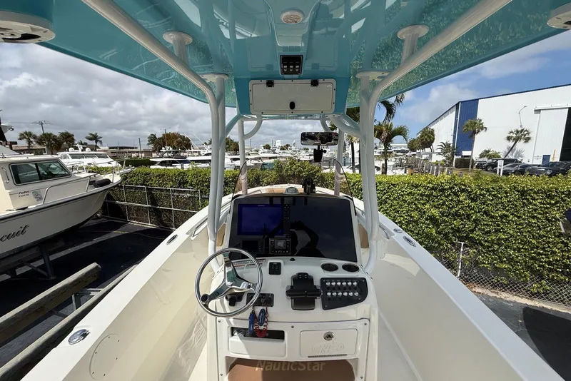 Slide: The Image of 2019 NauticStar 2602 Legacy boat cockpit with steering wheel and control panel. - 13