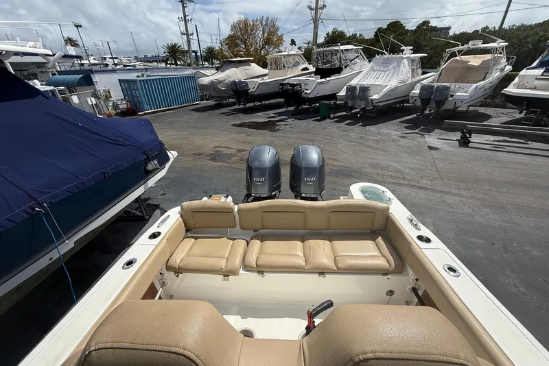 Slide: The Image of 2019 NauticStar 2602 Legacy boat with dual engines in a marina setting. - 14