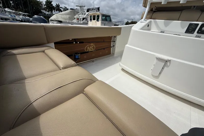 Slide: The Image of 2019 NauticStar 2602 Legacy boat interior with tan seating and white deck. - 8