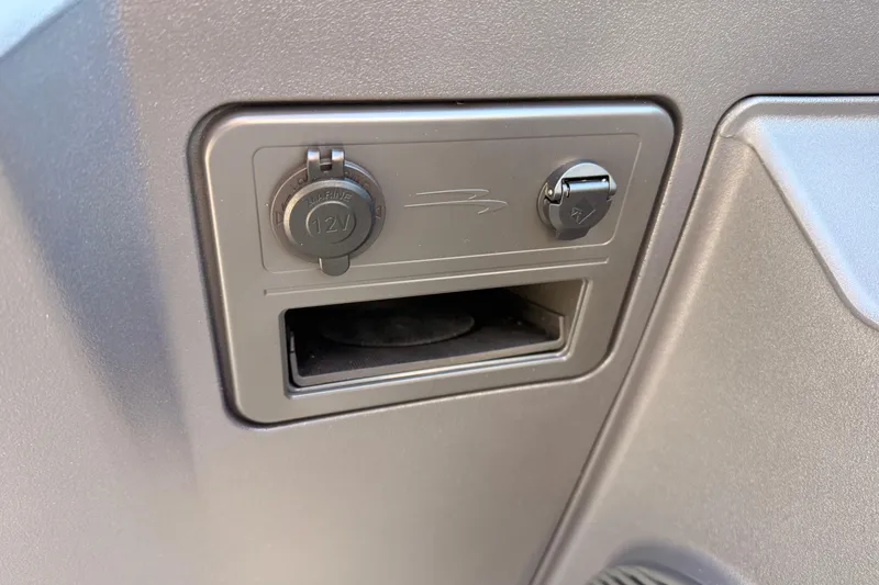 Slide: The Image of 12V power outlet on 2026 Bennington 22 S-One Quad Bench boat dashboard. - 24