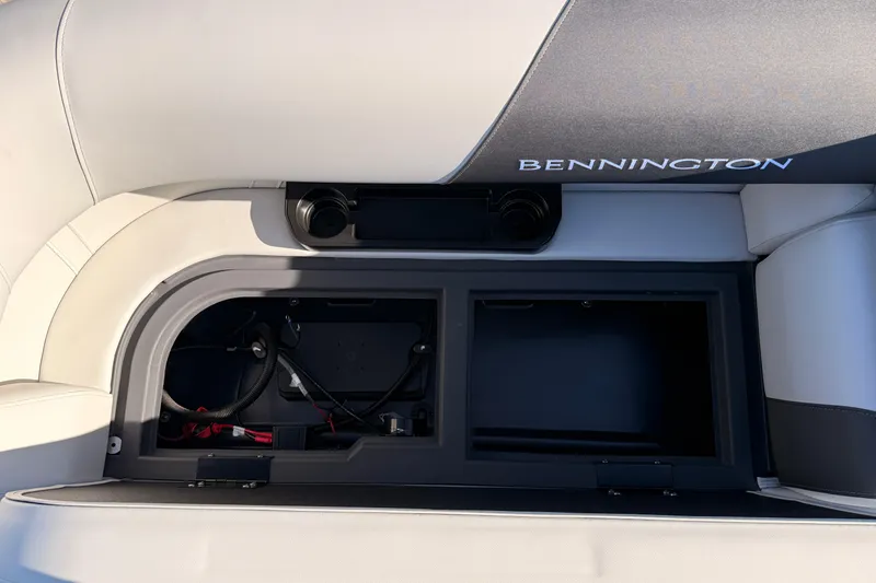 Slide: The Image of 2026 Bennington 22 S-One Quad Bench storage compartment with open lid, showcasing interior space. - 30