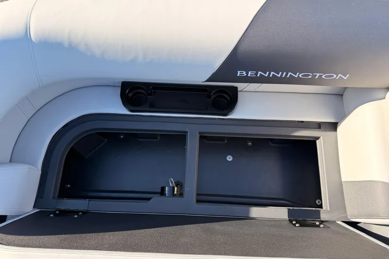 Slide: The Image of 2026 Bennington 22 S-One Quad Bench storage compartment with cup holders and sleek design. - 35