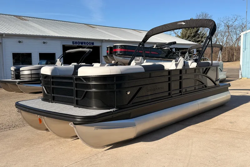 Slide: The Image of 2026 Bennington 22 S-One Quad Bench pontoon boat displayed outside a showroom. - 6