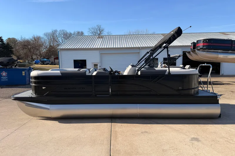Slide: The Image of 2026 Bennington 22 S-One Quad Bench pontoon boat parked outdoors. - 7