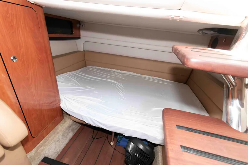 Slide: The Image of Interior cabin of 2015 Crownline 350 SY yacht with cozy bed and wooden accents. - 15