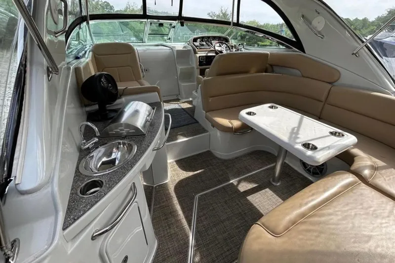 Slide: The Image of 2015 Crownline 350 SY yacht interior with seating, table, and kitchenette. - 6