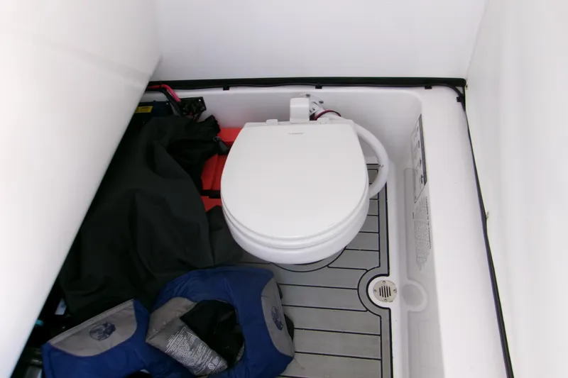 Slide: The Image of 2024 Sportsman Masters 267OE Bay Boat interior with toilet and storage area. - 11