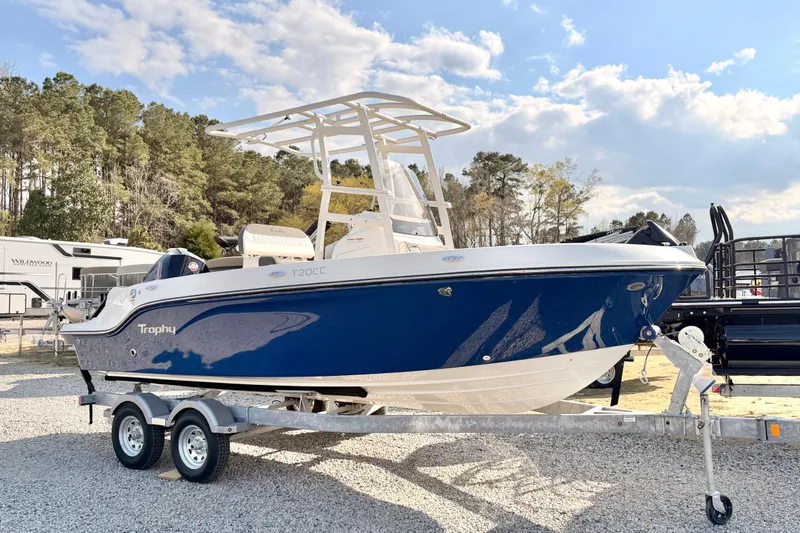 The Image of 2026 Bayliner Trophy T20CC boat on trailer, parked outdoors under a partly cloudy sky. - 2