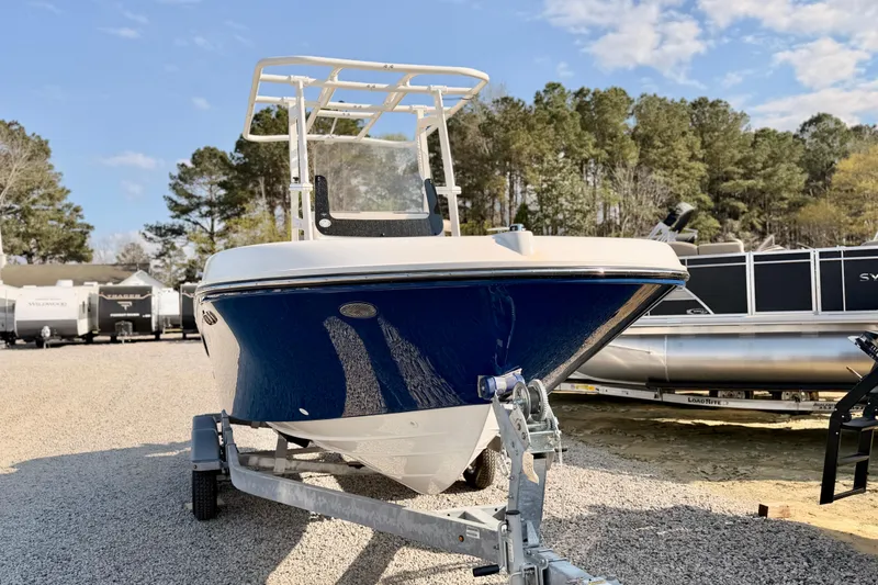 Slide: The Image of 2026 Bayliner Trophy T20CC boat on trailer, parked outdoors with trees in background. - 3