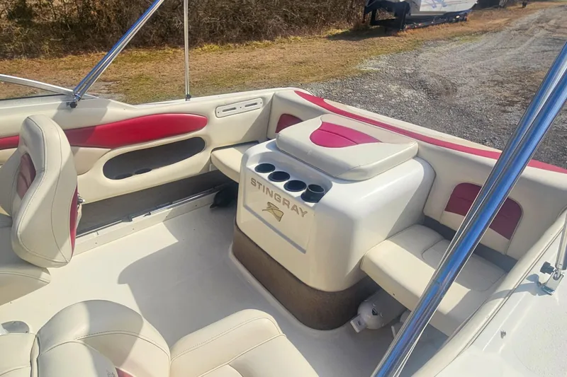 Slide: The Image of 1999 Stingray 220 CS boat interior with red and white seating and cup holders. - 4