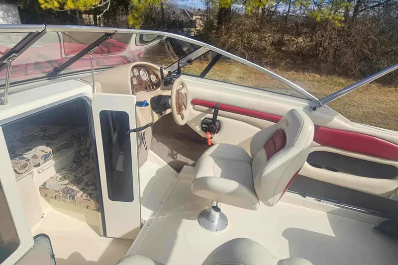 Slide: The Image of 1999 Stingray 220 CS boat interior with steering wheel, seating, and cabin entrance. - 5