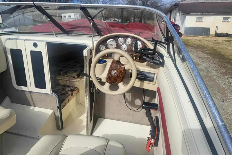 Slide: The Image of 1999 Stingray 220 CS boat interior with steering wheel and cabin entrance. - 6